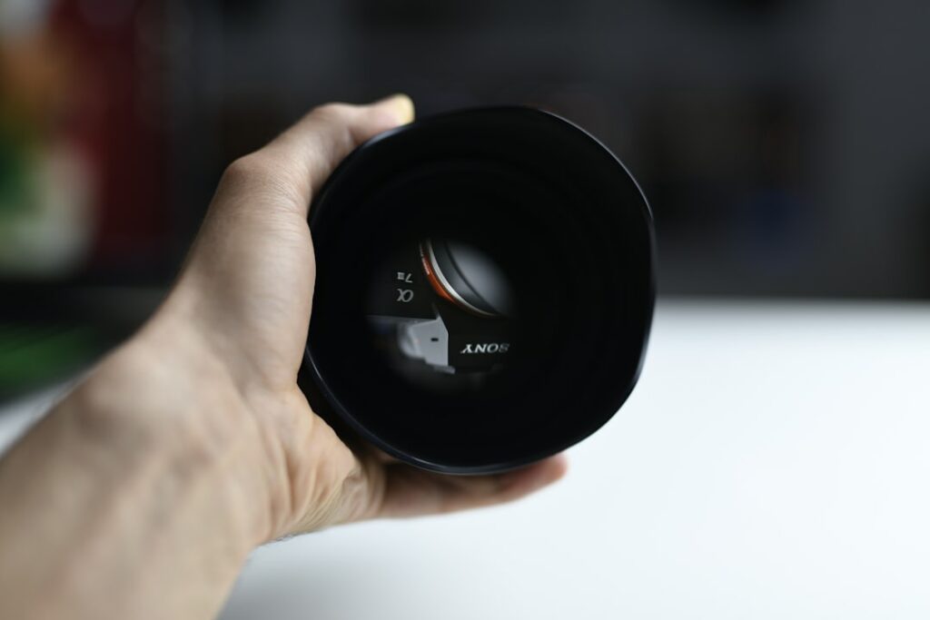 person holding black camera lens